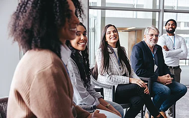 Teilnehmer sitzen bei einer Konferenz und diskutieren angeregt.