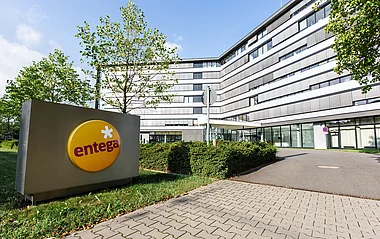 Der ENTEGA Hauptsitz in Darmstadt. Modernes Bürogebäude mit Grünflächen und Parkplätzen.