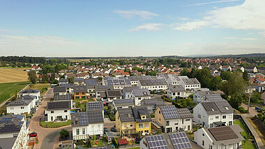 Satellitenaufnahme zeigt eine moderne Wohngegend mit Häusern und Solaranlagen auf den Dächern.