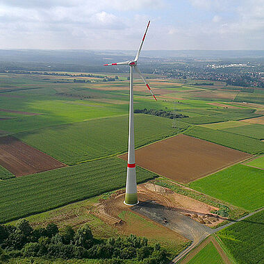Windkraftanlage in ländlicher Umgebung, aufgenommen aus der Vogelperspektive.