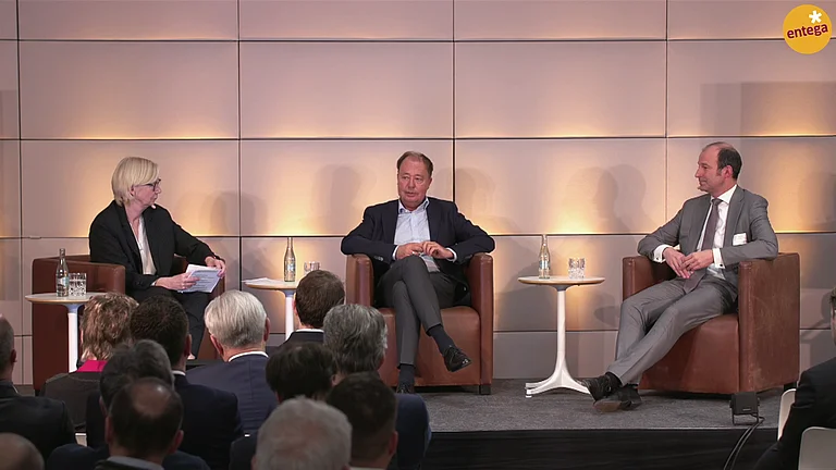 Podiumsdiskussion mit Führungskräften vor einer Konferenzpublikum.