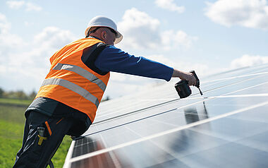 Solaranlagen-Techniker montiert ein Solarmodul auf dem Dach.