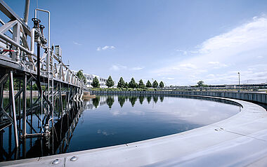 Klärbecken mit technischer Infrastruktur und umliegender Landschaft.