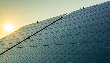 Moderne Glasfassade reflektiert den Sonnenuntergang.