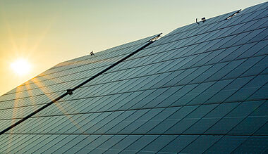 Moderne Glasfassade reflektiert den Sonnenuntergang.