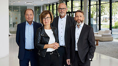 Der vierköpfige ENTEGA-Vorstand in formeller Kleidung posiert für ein professionelles Porträt.