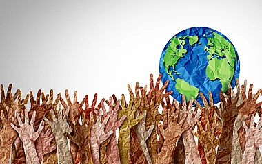 Viele Hände reichen nach einer Darstellung der Erde.