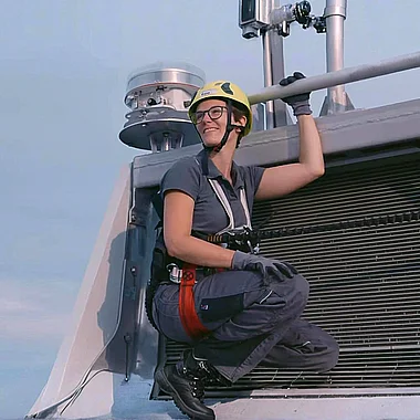 Eine Technikerin inspiziert eine Windkraftanlange.