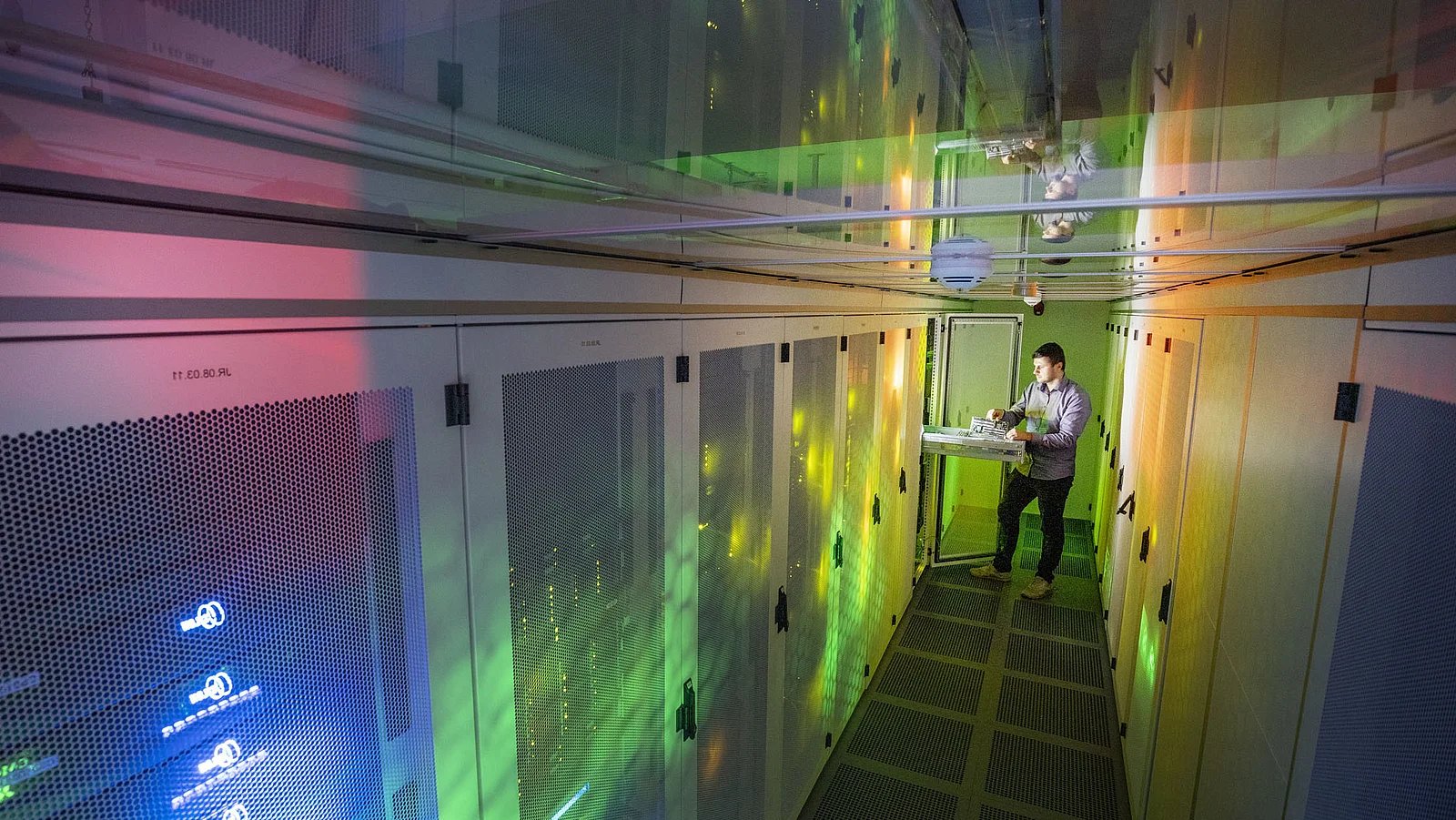 Techniker inspiziert Serverracks in einem modernen Rechenzentrum.