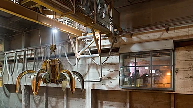 Greifarm bewegt sich über dem Müllbunker des Mullheizkraftwerks.