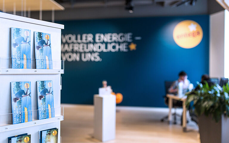 Moderne Büroräume mit Mitarbeitern und Pflanzen im Hintergrund.