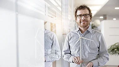 Ein Ingenieur hält ein Messgerät zur Analyse von Winddaten.