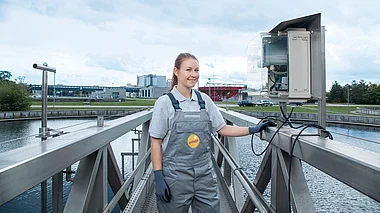 Mitarbeiterin inspiziert eine Kläranlage bei routinemäßigen Wartungsarbeiten.