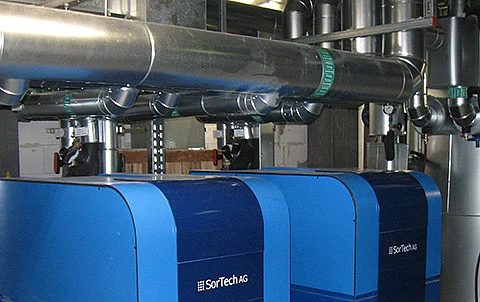 Industrielle Anlage mit Rohren und technischen Komponenten im Innenbereich.