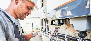 Techniker installiert eine elektrische Verbindung an einem Verteilerkasten.