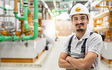 Techniker steht in einer Industrieanlage, prüft Prozesse.