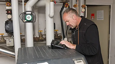 Techniker inspiziert eine Anlage in einem Technikraum.