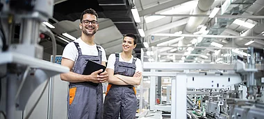 Techniker inspizieren Produktionsanlagen in einer modernen Fabrikhalle.