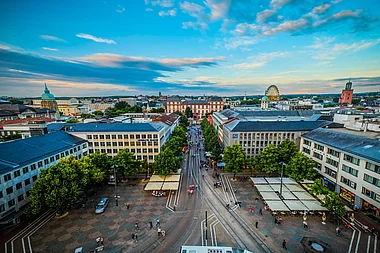 Überblick über die belebte Innenstadt von Darmstadt mit historischen Gebäuden und Verkehr.