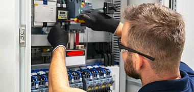 Techniker installiert Verbindungen in einem elektrischen Schaltschrank.