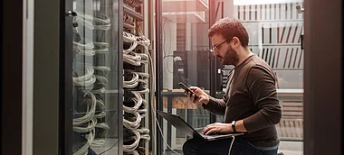 Techniker überprüft Serverausrüstung in einem Rechenzentrum.