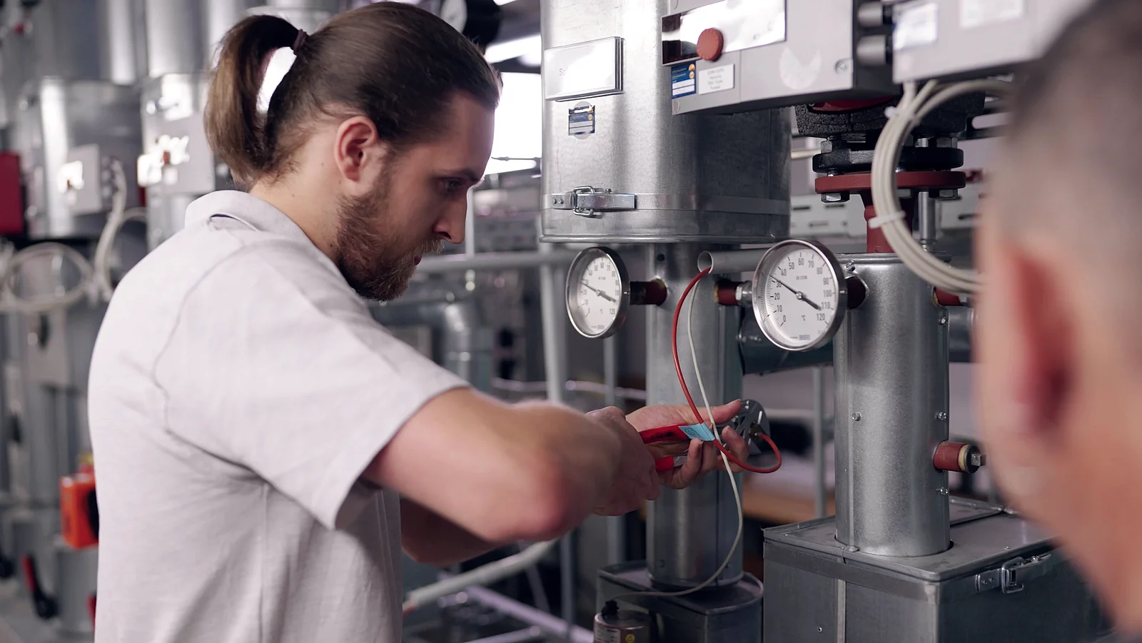 Techniker inspiziert eine Anlage mit Messinstrumenten und Ventilen.