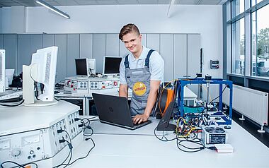 Techniker arbeitet in einem Labor mit Messgeräten und einem Laptop.