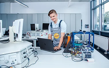 Techniker arbeitet in einem Labor mit Messgeräten und einem Laptop.