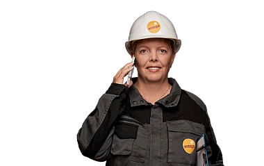 Technikerin telefoniert während der Arbeit auf einer Baustelle.