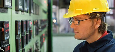 Techniker überprüft Messwerte an einem Schaltfeld.