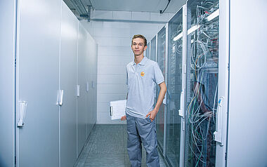 Techniker inspiziert Serverraum mit Netzwerktechnik.