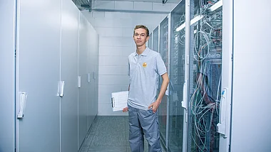 Techniker inspiziert Serverraum mit Netzwerktechnik.