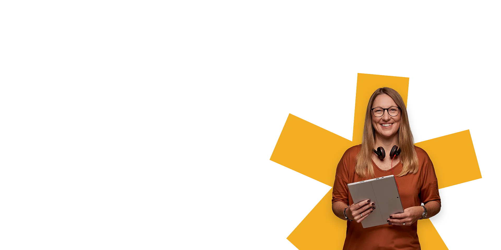 Eine Frau hält ein Tablet und lächelt freundlich in die Kamera.